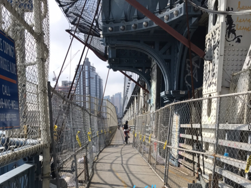 The portion of the Manhattan Bridge bike lane that is significantly narrowed by chain link fences